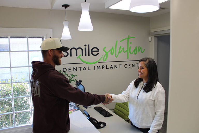 Front desk staff shaking hands with a patient